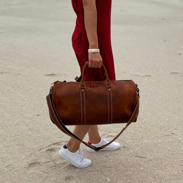 girl holding her brown leather ode federation duffle bag