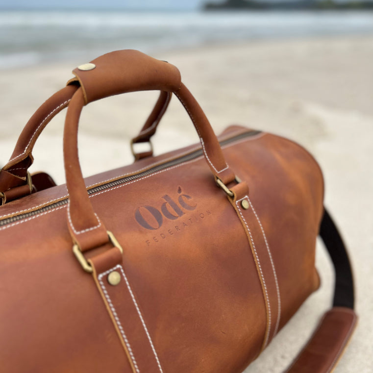 brown leather weekend bag on the beach